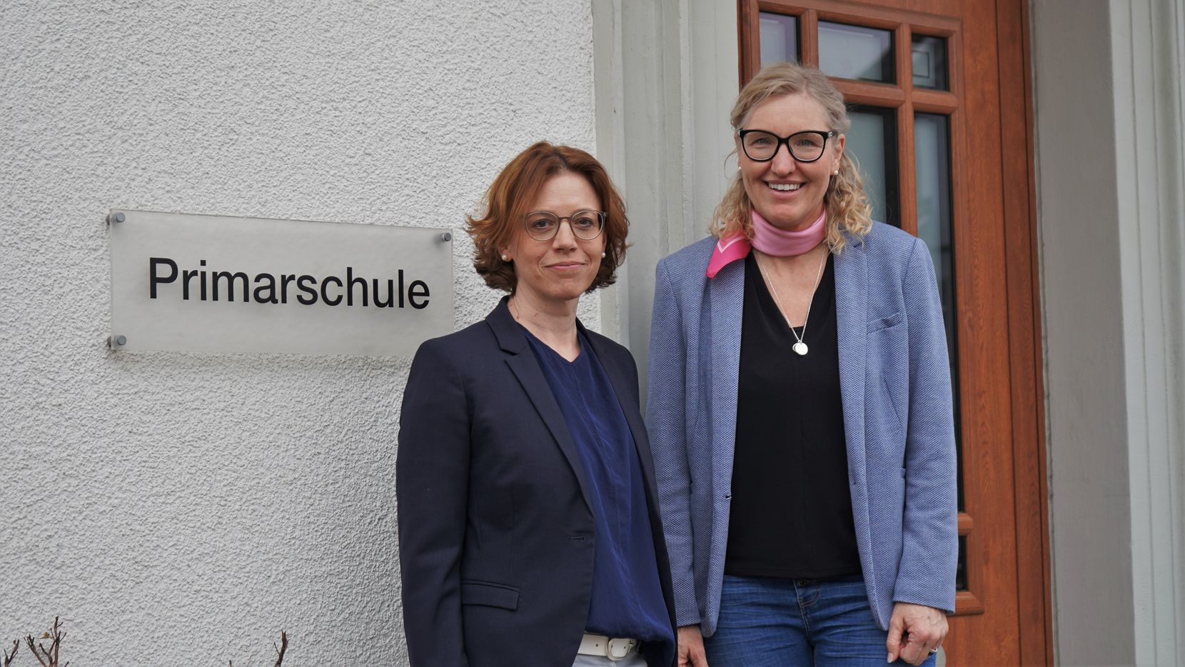 Zwei Frauen stehen vor dem Primarschulgebäude